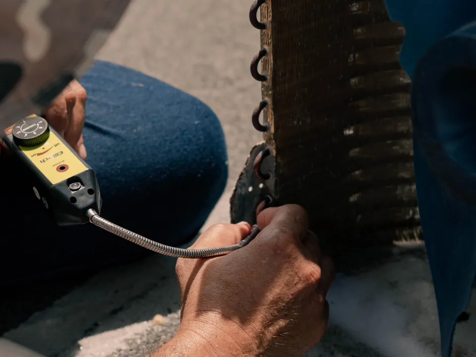 Technician checking an air conditioner unit with service tools
