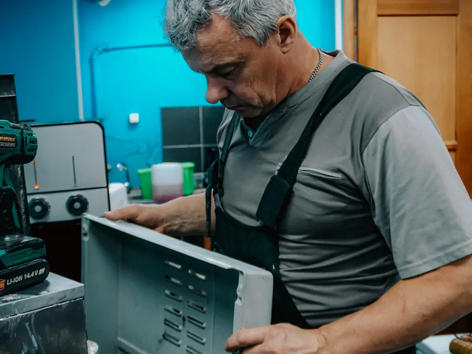 Technician examining a home appliance indoors