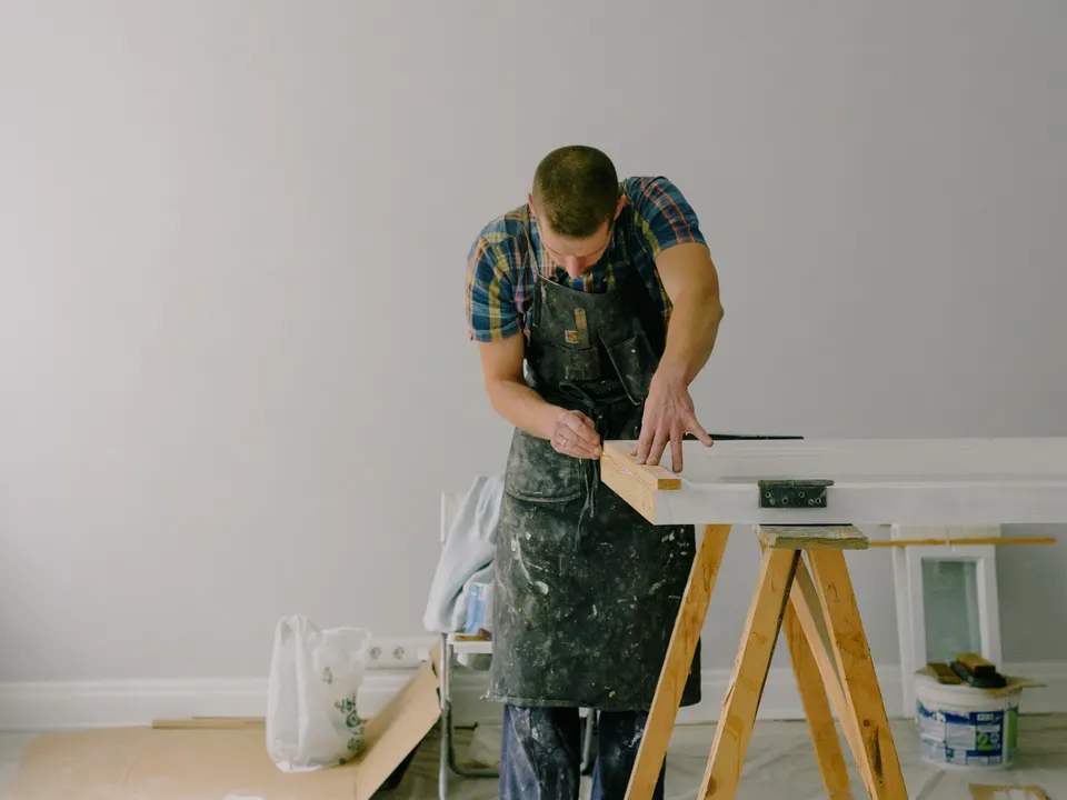 Craftsman measuring timber during indoor carpentry work